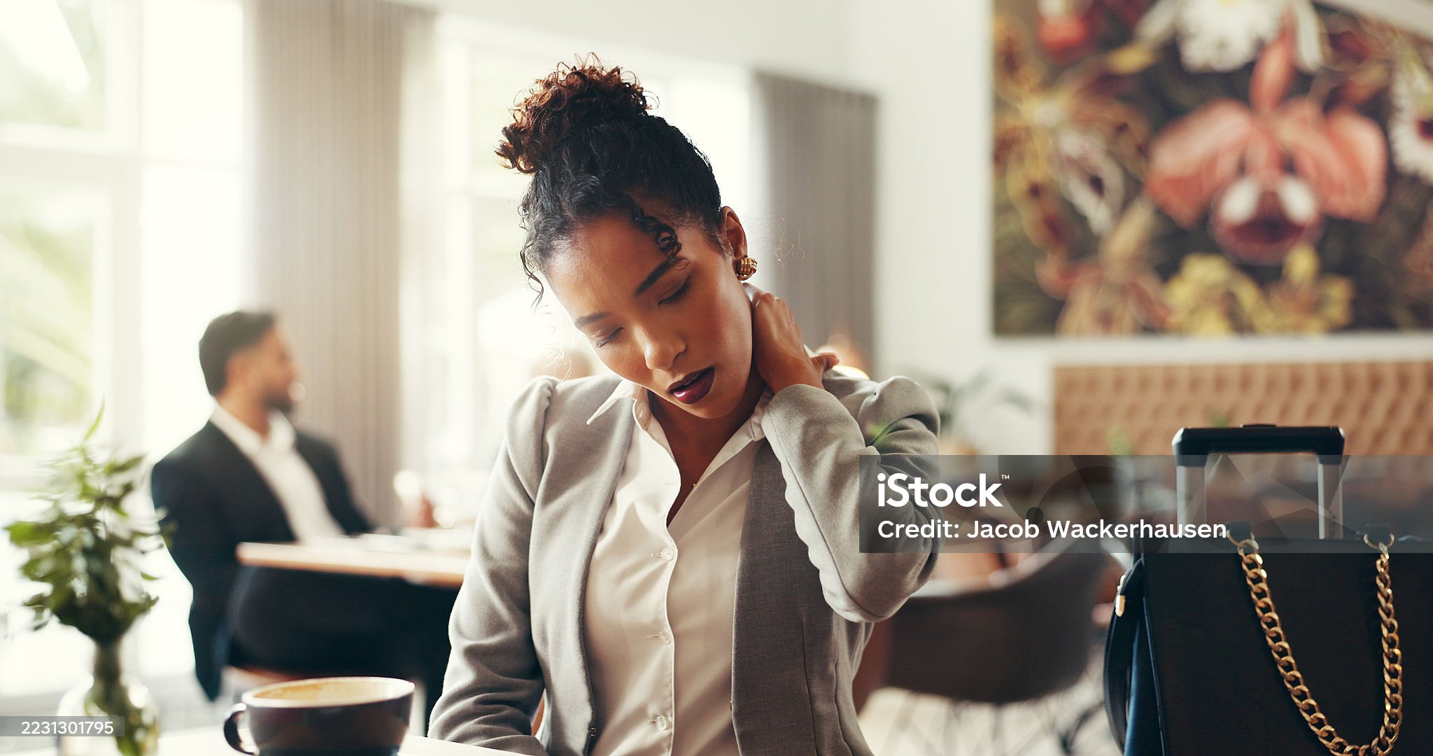 Professional woman experiencing neck pain while working in modern office